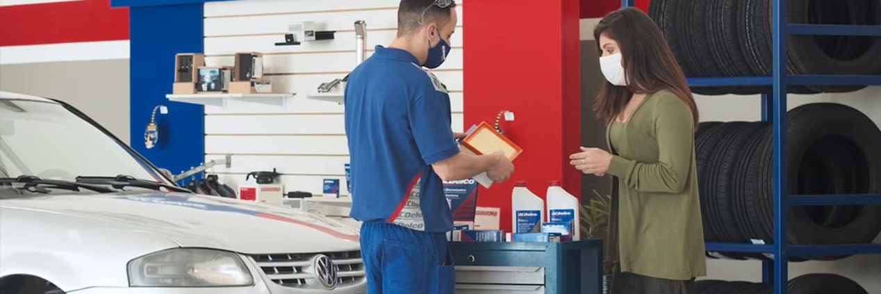 Atendente mostrando produtos para cliente no centro automotivo da ACDelco