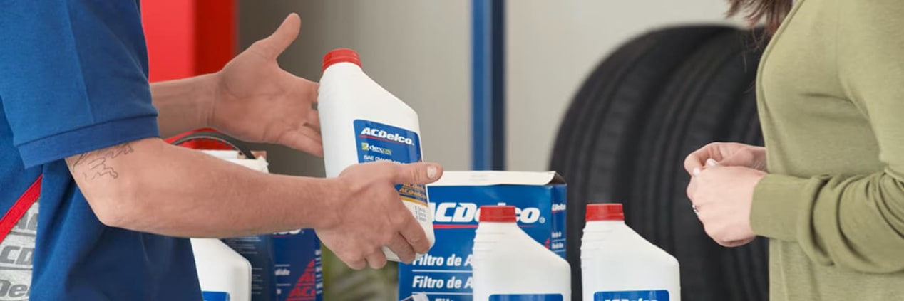 Atendente mostrando produtos para cliente no centro automotivo da ACDelco